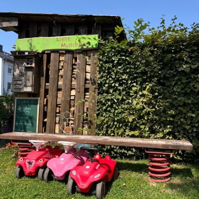 3 Bobbycar nebeneinander geparkt unter einem Balancierbalken