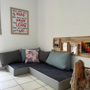 Leseecke der Little Munchkins mit kleinem Sofa, Büchern und Kissen